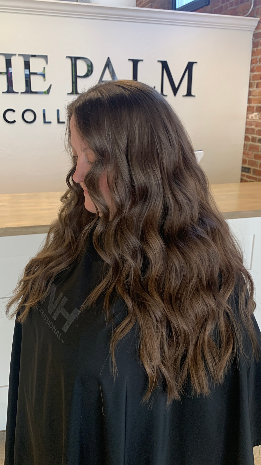 Long brunette hair extensions styled in loose waves by Emma Yook
